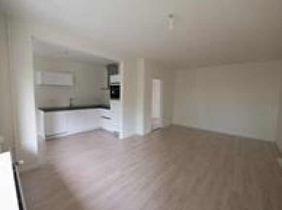 Woonkamer met open keuken en toegang naar balkon op ZW.